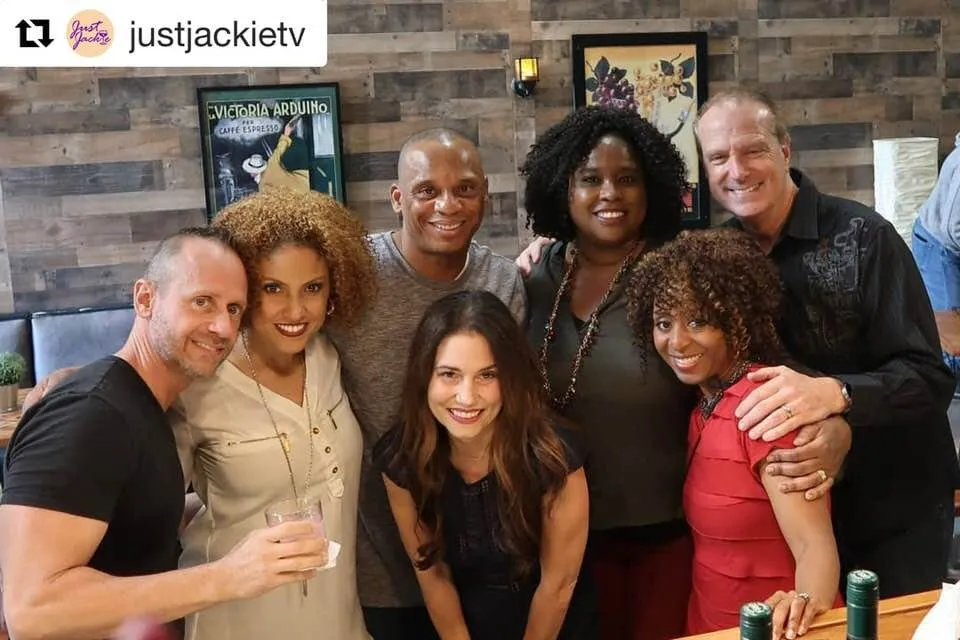 Seven smiling cast and crew of Just Jackie pose together in a restaurant after the Girls’ Night Out shoot, in a repost from justjackietv.