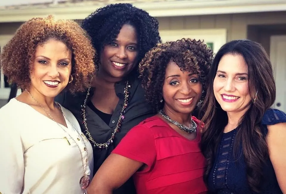 The four bookclub ladies of Just Jackie TV season 2 smiling close together in front of a house