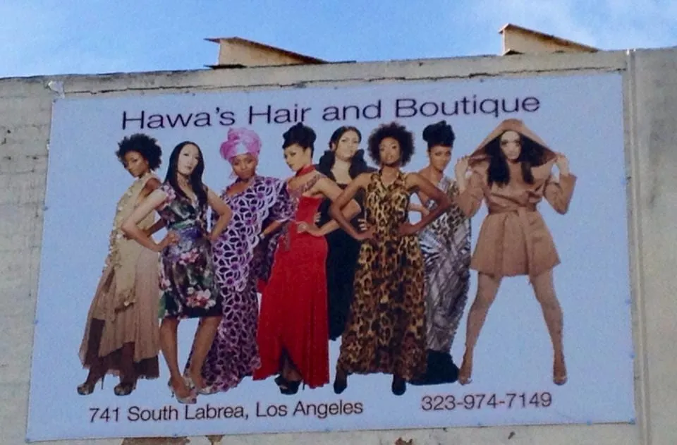 Billboard for Hawa’s Hair and Boutique, 741 South Labrea, Los Angeles, with eight models in gowns including Sophia Thomas in lavender African attire