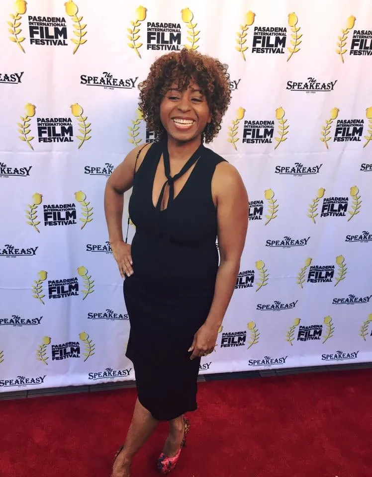 Sophia Thomas smiling in a black dress on the red carpet at the Pasadena International Film Festival, for My Name Is Lamar.